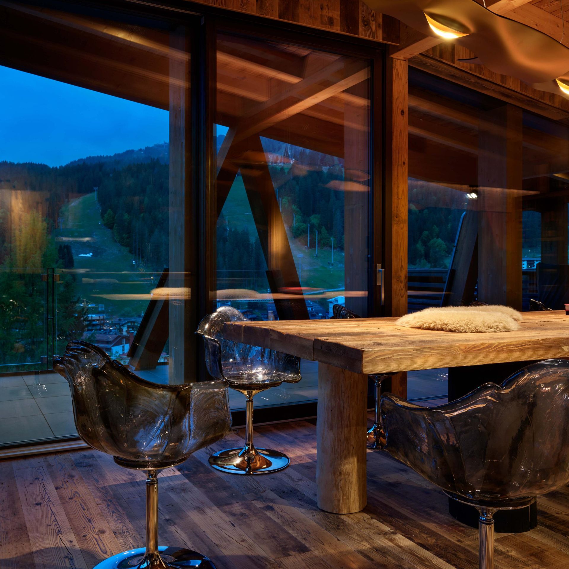   Ella . Im Esszimmer wirken die Polycarbonat-Sessel mit ihren schwarzen und anthrazitgrauen Reflexen wie Lichtpunkte, die sich rund um den gro&szlig;en Holztisch entz&uuml;nden. 